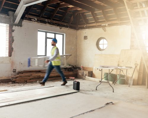 Construction, house and contractor walking in a building with maintenance, renovation and work with.