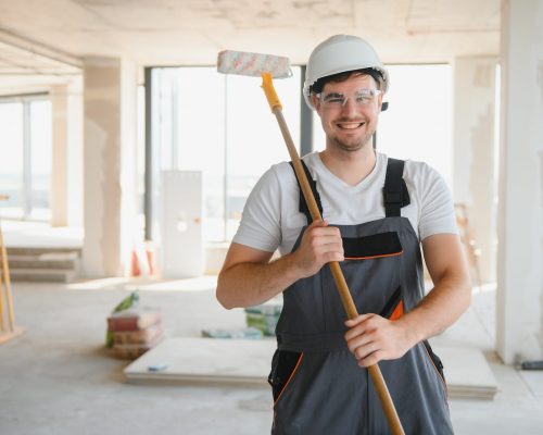 painter man painting the wall, with paint roller.